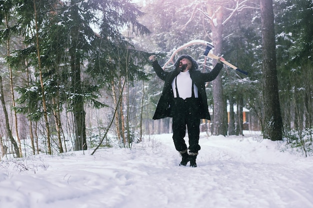 Homme barbu dans les bois d'hiver. Séduisante jeune homme heureux avec barbe marche dans le parc.