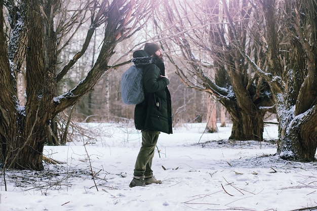 Homme barbu dans les bois d'hiver. Séduisante jeune homme heureux avec barbe marche dans le parc.