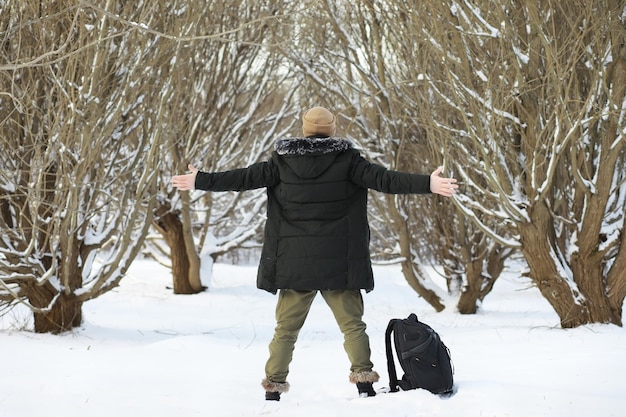 Homme barbu dans les bois d'hiver. Séduisante jeune homme heureux avec barbe marche dans le parc.