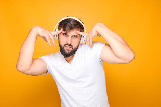 L'homme barbu dans les écouteurs exécute émotionnellement des mouvements de danse sur de la musique.