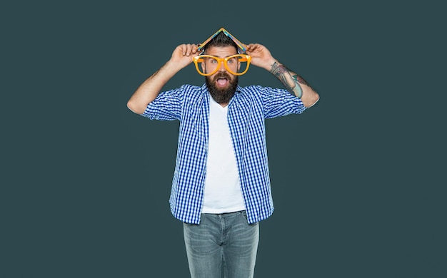 Homme barbu drôle dans des verres de fête avec un livre sur l'éducation de la tête