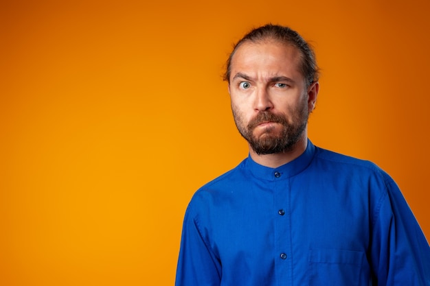 Homme barbu étonné et confus regarde avec étonnement