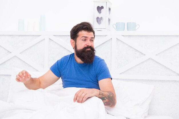 Un homme barbu fatigué et endormi s'est réveillé tôt le matin avec des problèmes de sommeil et d'insomnie