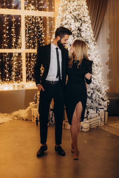 Homme barbu et femme près de sapin de Noël