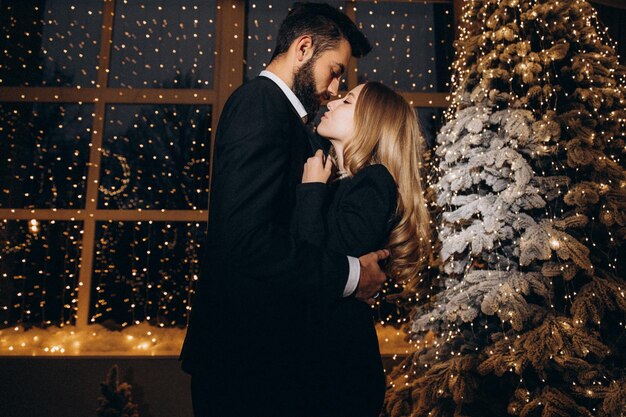 Homme barbu et femme près de sapin de Noël