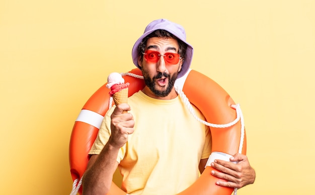 Homme barbu fou expressif portant un chapeau et des lunettes de soleil avec une glace