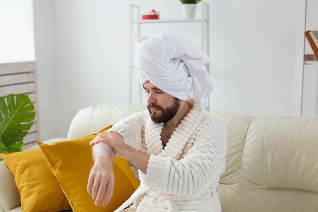 L'homme barbu frotte de la crème pour les mains sur ses mains. Spa, soins du corps et de la peau pour homme concept