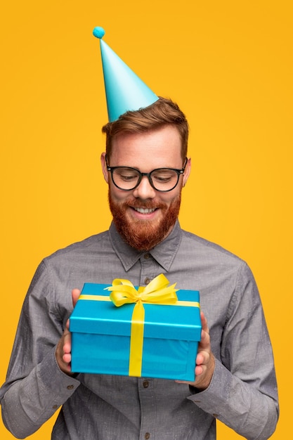 Homme barbu gai avec boîte-cadeau