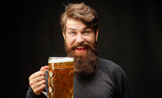 Un homme barbu heureux buvant de la bière dans un bar. C'est une fête en Allemagne.