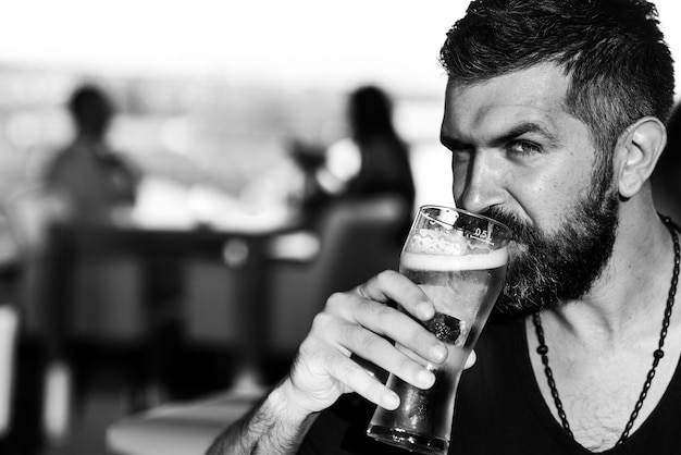 Homme barbu hipster brutal assis au comptoir du bar Pubs et bars à bière