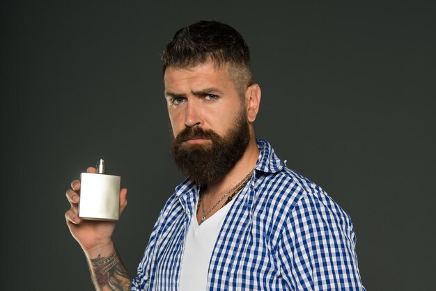 Homme barbu hipster caucasien brutal avec moustache Soins du visage Mode masculine Hipster mature avec barbe homme présentant l'arôme et l'odeur du produit de parfum Profiter de la routine du matin