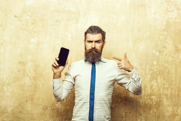 Homme barbu ou hipster avec une longue barbe tenir le téléphone