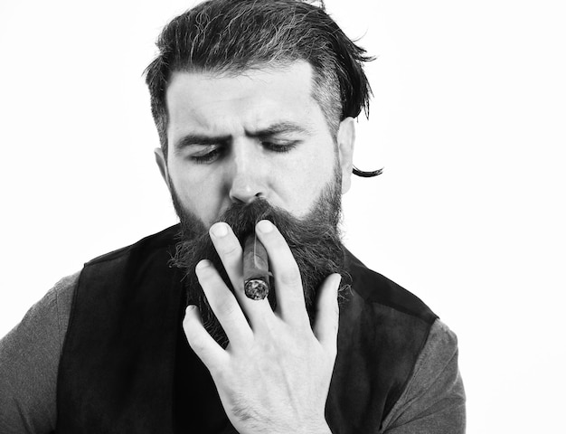 Homme barbu longue barbe hipster caucasien brutal avec moustache fumer cigare avec visage sérieux isolé sur fond blanc gros plan