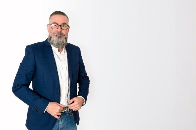 Homme barbu avec des lunettes et hâte de poser avec élégance