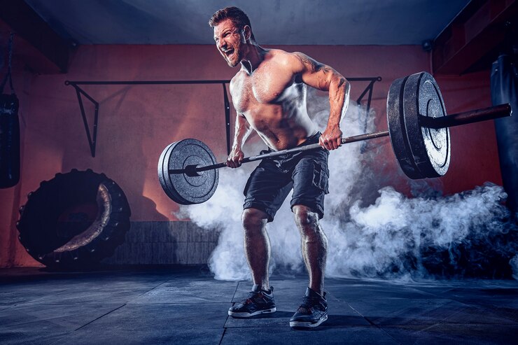 Photo homme barbu musclé travaillant dans une salle de sport à faire des exercices, fort torse nu masculin abs. fumée sur le mur