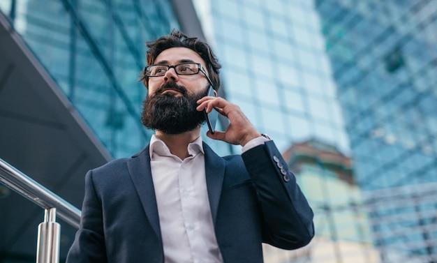 Homme barbu occupé parlant au téléphone