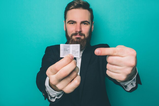 Homme barbu pointe sur un petit morceau de papier