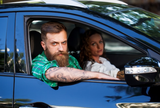 Un homme barbu avec sa petite amie dans la voiture.