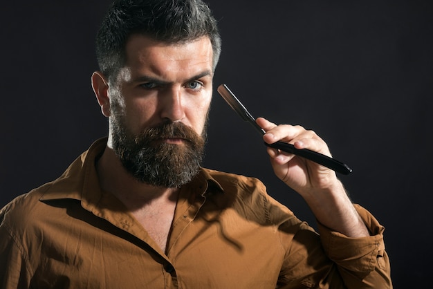 Homme barbu se rasant dans un salon de coiffure avec un équipement de salon de coiffure à lame de rasoir bel homme barbu