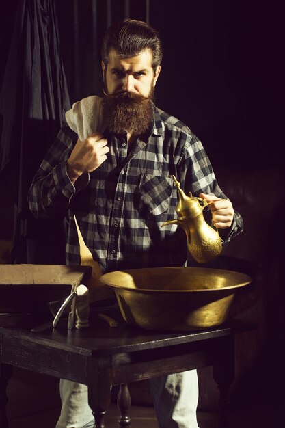 L'homme barbu se rase avec un rasoir