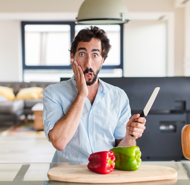 Homme barbu se sentant choqué et effrayé, l'air terrifié avec la bouche ouverte et les mains sur les joues