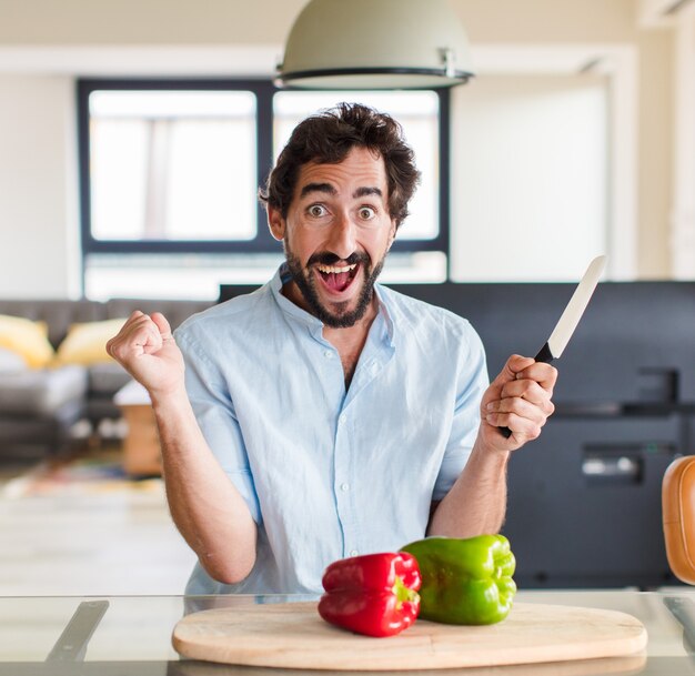 Homme barbu se sentant choqué, excité et heureux, riant et célébrant le succès, disant wow!