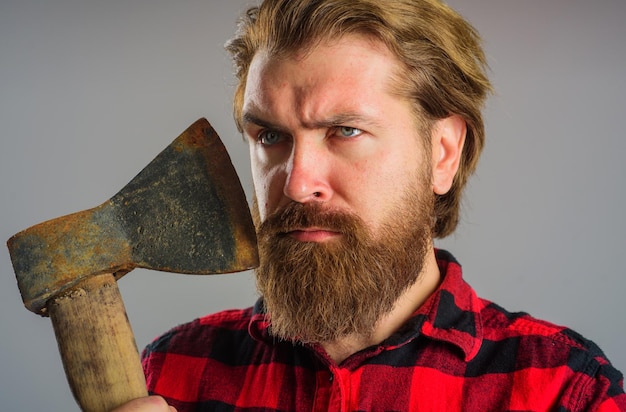 Homme barbu sérieux avec une hache de bûcheron canadien avec de vieux outils de bûcheron de bois de coupe de hache