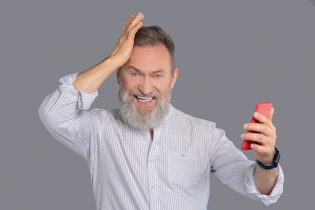 Homme barbu avec un smartphone dans les mains