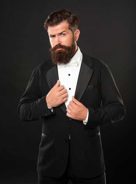 Homme barbu en smoking sur fond noir noeud papillon