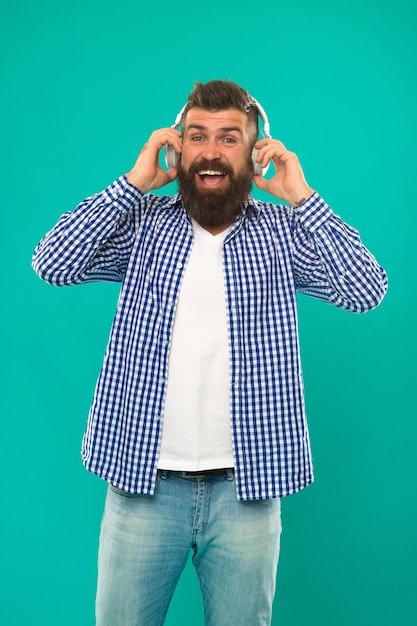 Homme barbu. Soins des cheveux et de la barbe. Heureux homme hipster écouter de la musique. L'homme dans les écouteurs. Jeune et brutal. Hipster mature avec barbe. musique. hipster caucasien brutal avec moustache. livre audio.