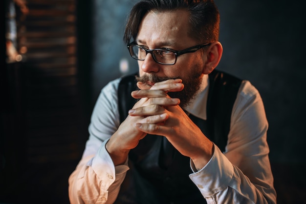 Homme barbu sombre et sombre dans des verres