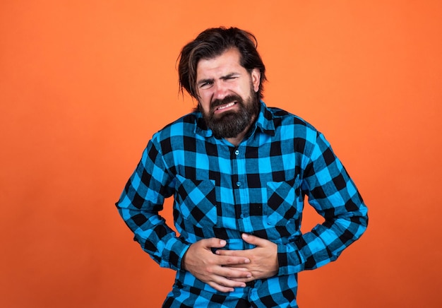 Un homme barbu souffrant de maux d'estomac a des douleurs dans la médecine et la santé de la cavité abdominale