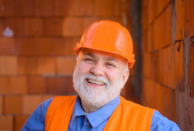 Homme barbu de technologie de l'industrie du bâtiment en costume avec constructeur de casque de construction dans un casque