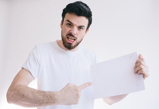 Homme barbu tenant une feuille de papier blanc vierge