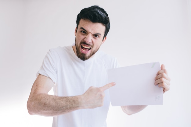 Homme barbu tenant une feuille de papier blanc vierge