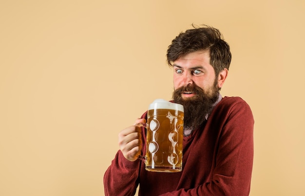 Un homme barbu tient un verre à bière bel homme boit de la bière au bar ou au pub barbu homme buvant de la bière dans une tasse