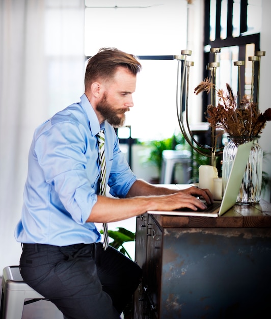 Homme barbu travaillant sur un ordinateur portable