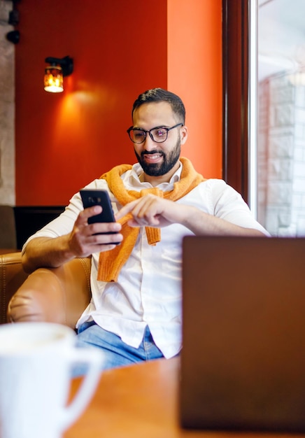 Homme barbu travaillant et vérifiant ses e-mails sur ordinateur