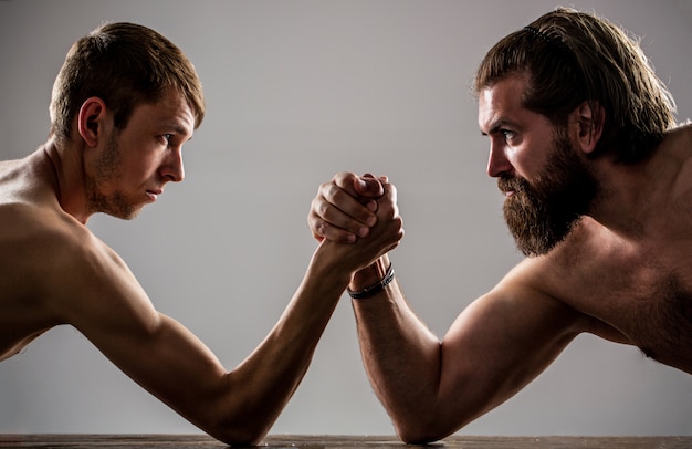 Homme barbu très musclé lutte contre un homme faible et chétif