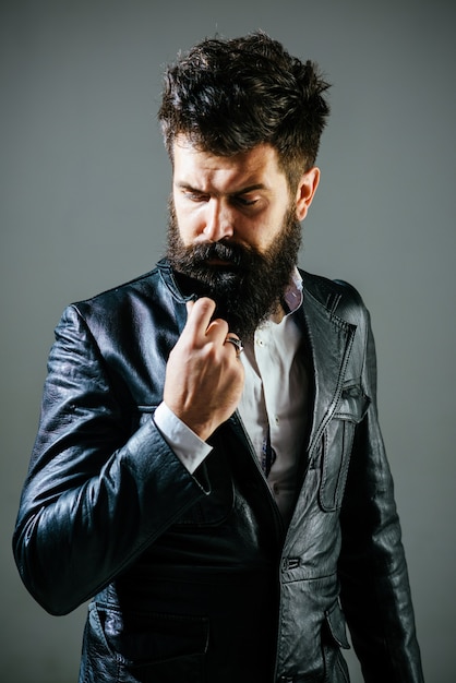 Homme barbu en veste noire homme pensif en veste en cuir salon de coiffure concept mode à la mode