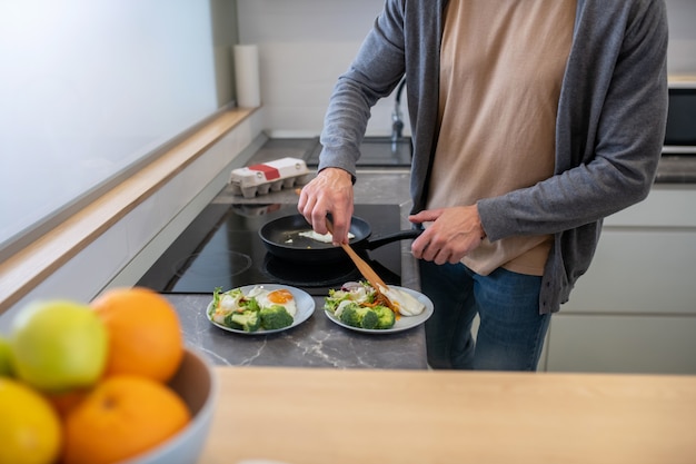 Un homme bardé d'âge mûr cuisine dans la cuisine