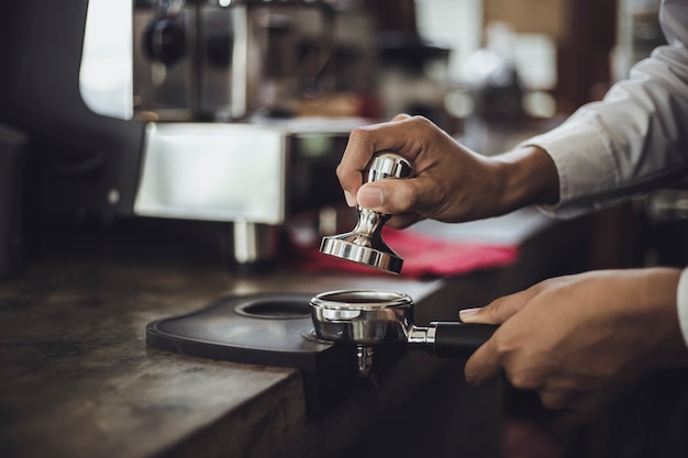 Homme Barista préparant un café pour le client dans un café. Propriétaire de café servant un client au café.