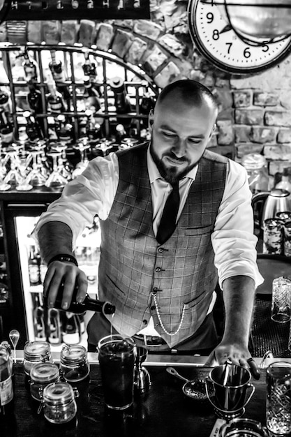 Homme barman au travail Le barman mélange des cocktails