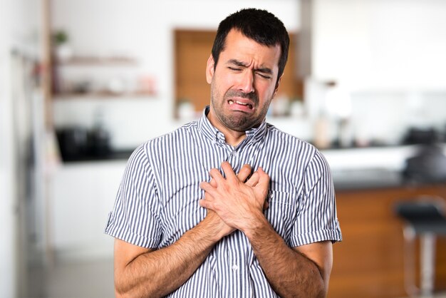 Un homme beau avec une douleur cardiaque dans la maison