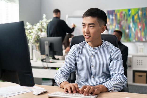 Un homme de beauté coréenne asiatique est assis devant un ordinateur de bureau à l'aide d'un navigateur Web