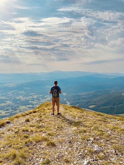 L'homme bénéficie d'une vue sur le village alpin dans les collines. vacances. Slovénie. Voyager