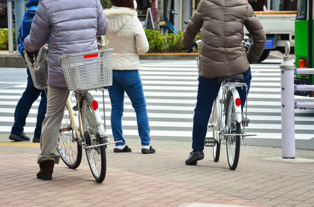 Photo homme à bicyclette et piéton au croisement attendant de traverser la route sur le zèbre