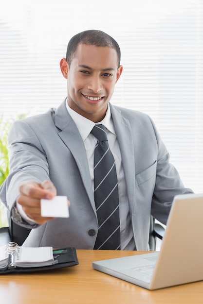 Homme bien habillé, remise de carte de visite en face de l&#39;ordinateur portable au bureau