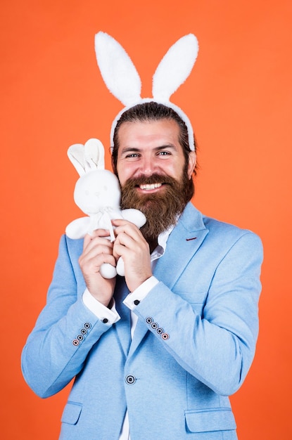 Photo homme bien soigné en tenues de soirée de mariage et oreilles de lapin a barbe joyeuses pâques