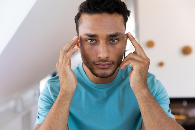 Photo un homme biracial se touchant le visage, regardant dans le miroir de la salle de bain. style de vie, soins personnels et vie domestique, inchangés.